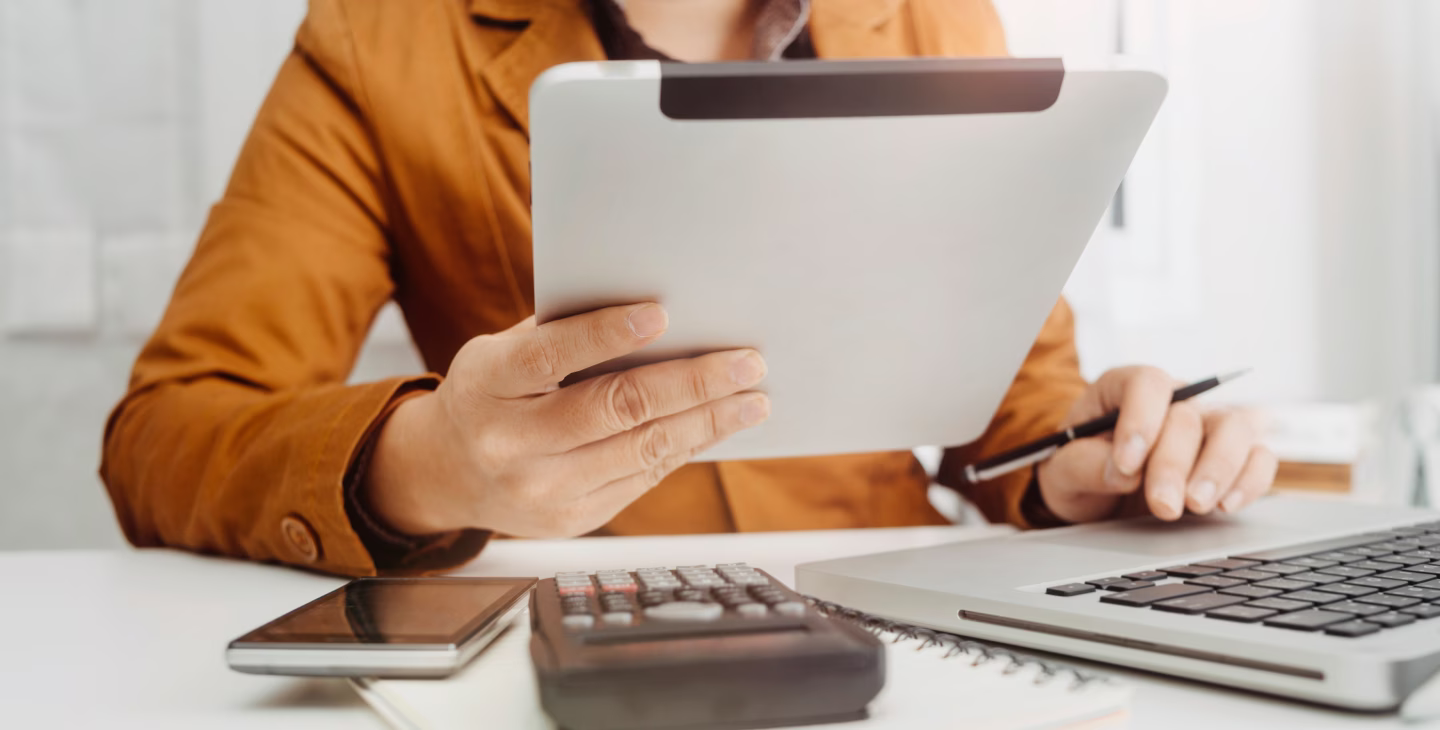 Professionnel utilisant une tablette et un ordinateur pour gérer l’ERP et la facturation électronique en entreprise.