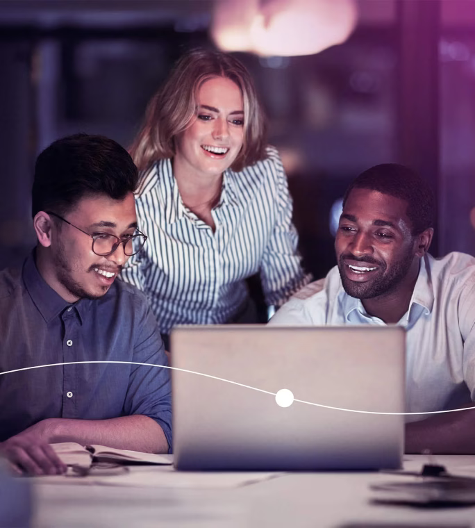 Trois collègues, deux hommes et une femme, sourient en observant un ordinateur portable et utilisant Mywave dans un environnement de bureau moderne et lumineux.