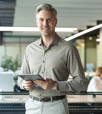 Manager souriant tenant une tablette pour superviser les opérations avec SAP Business One Field Service Management.